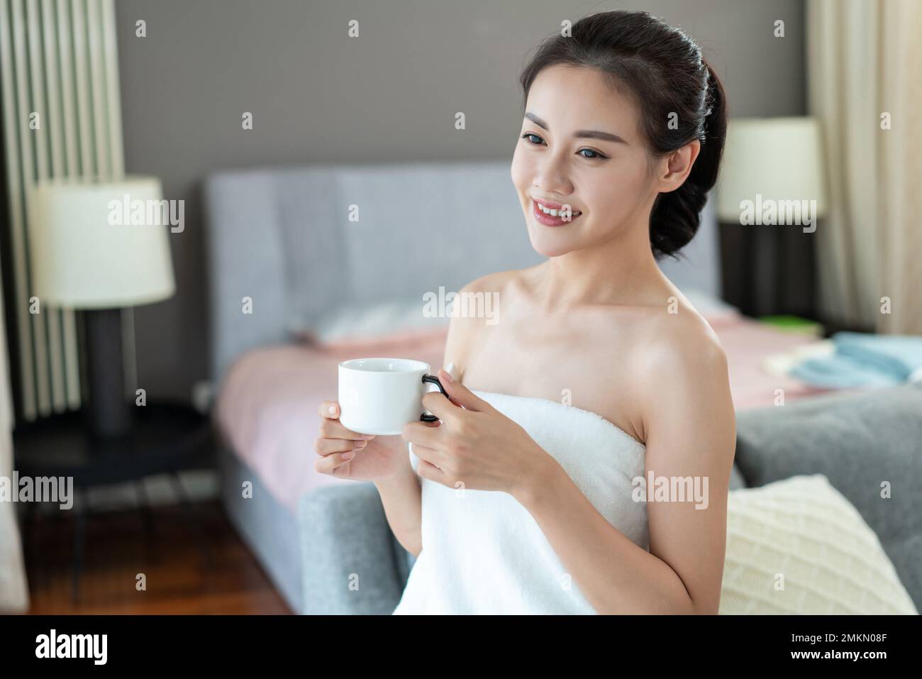 Young lady wearing a bathrobe sat near the window Stock Photo Alamy