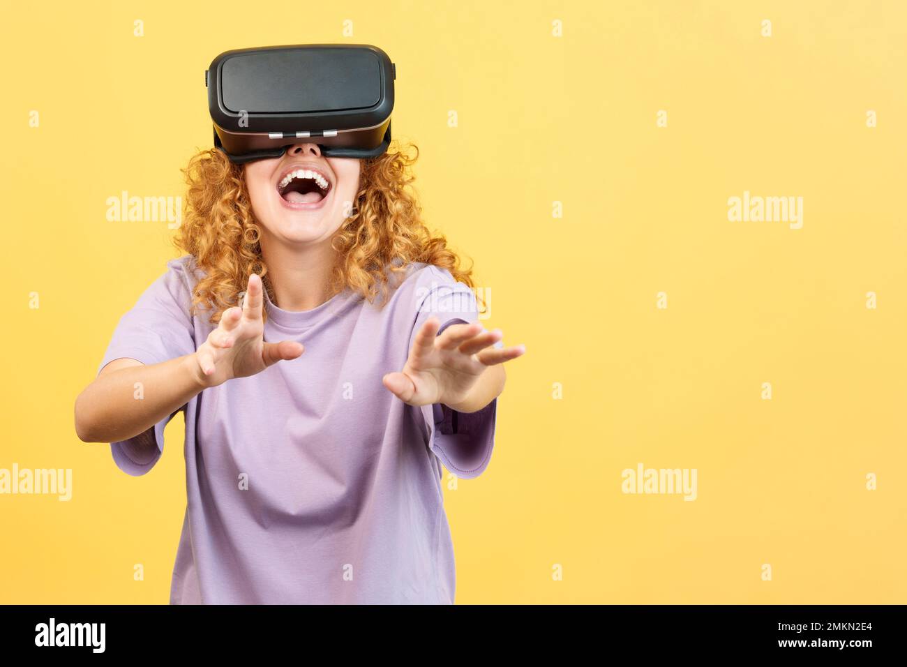 Surprised woman smiling while using virtual reality goggles Stock Photo