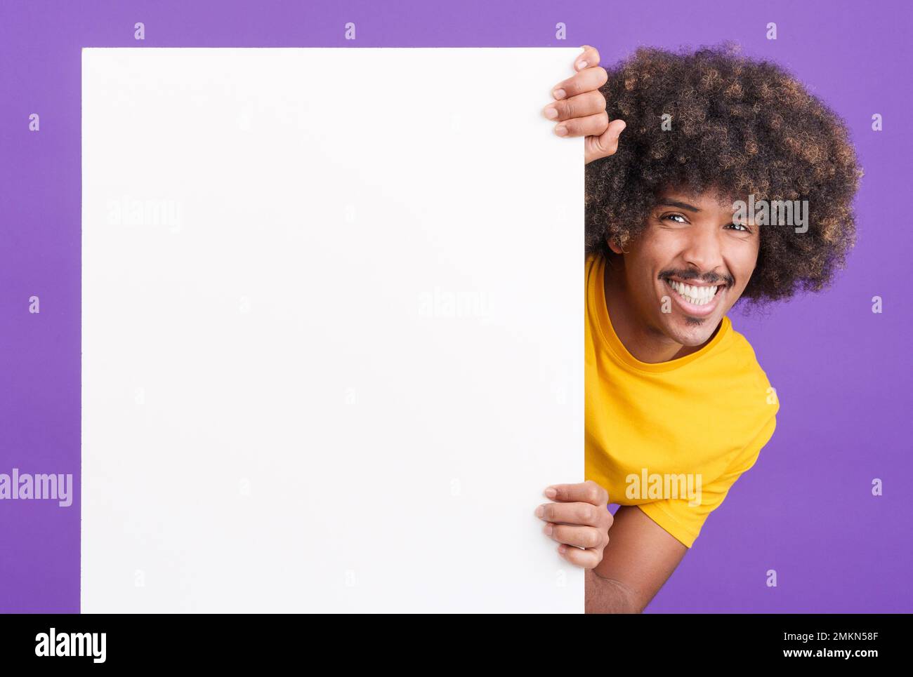 Smiley african man with curly hair holding a blank panel Stock Photo