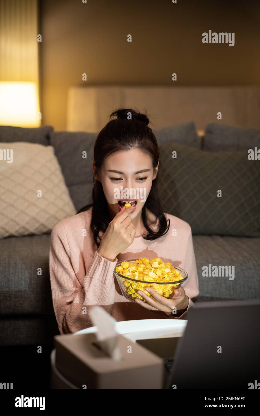 The young lady eat at home use the computer Stock Photo Alamy