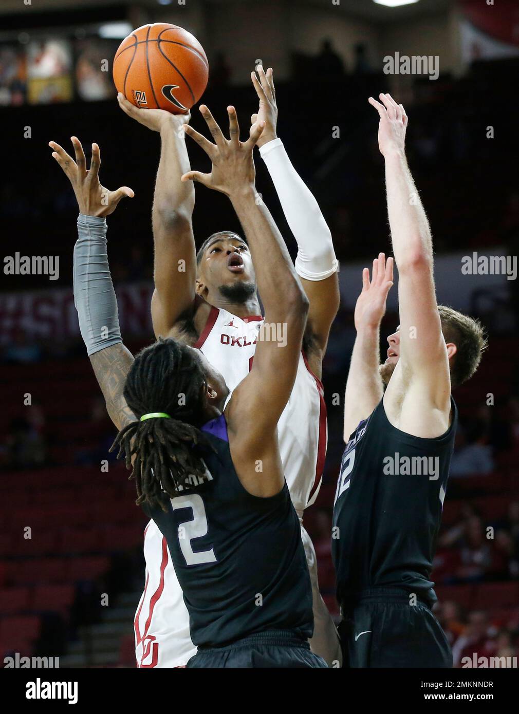 Oklahoma guard Christian James center shoots between Kansas