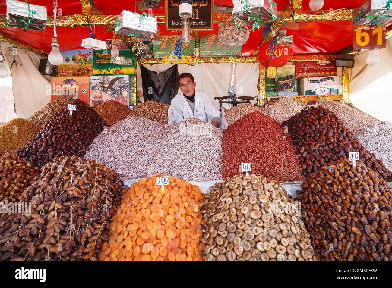 MARRAKESH, MOROCCO - March 10, 2007. Muslim man selling dates and other dried fruit on a market stall in Medina souk, Marrakech, Morocco Stock Photo