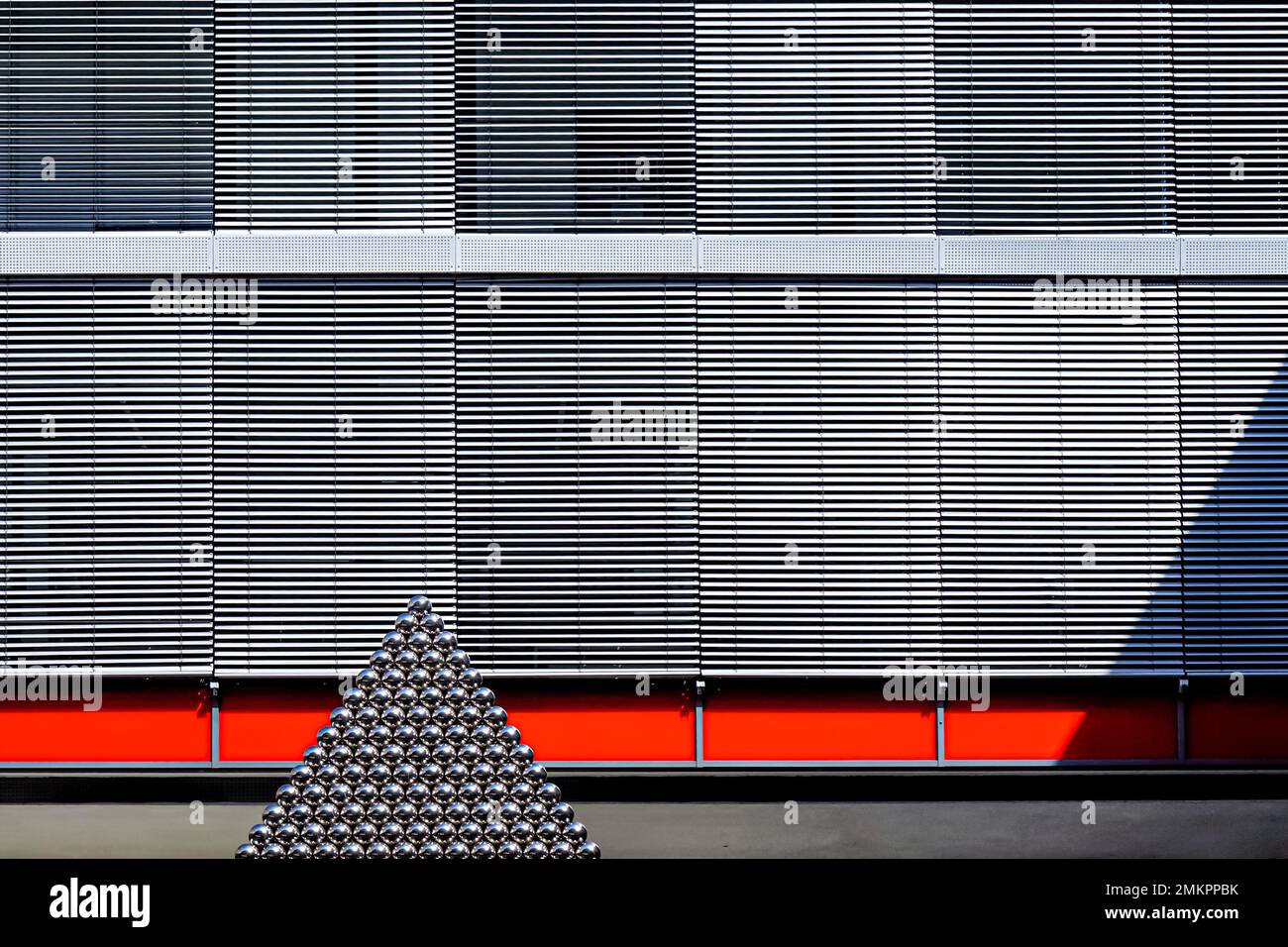 View of a metal pyramid which is casting a shadow in the courtyard of the computer center and library of the Augsburg University of Applied Sciences. Stock Photo