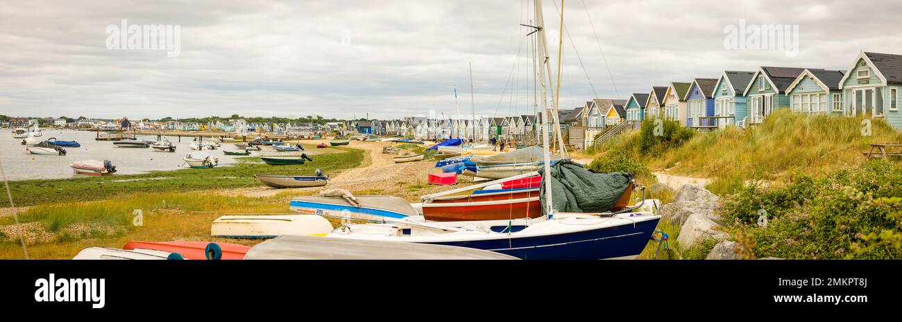 DORSET, UK - July 07, 2022. Rows of boats and beach huts at the seaside. Panoramic view of Hengistbury Head and Christchurch Harbour Stock Photo
