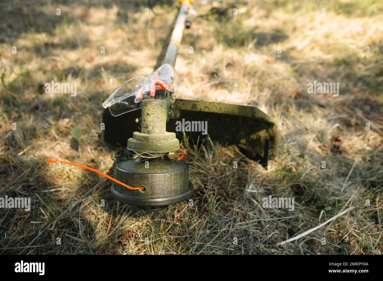 Trimmer after mowing grass closeup. Petrol pump on the grass with