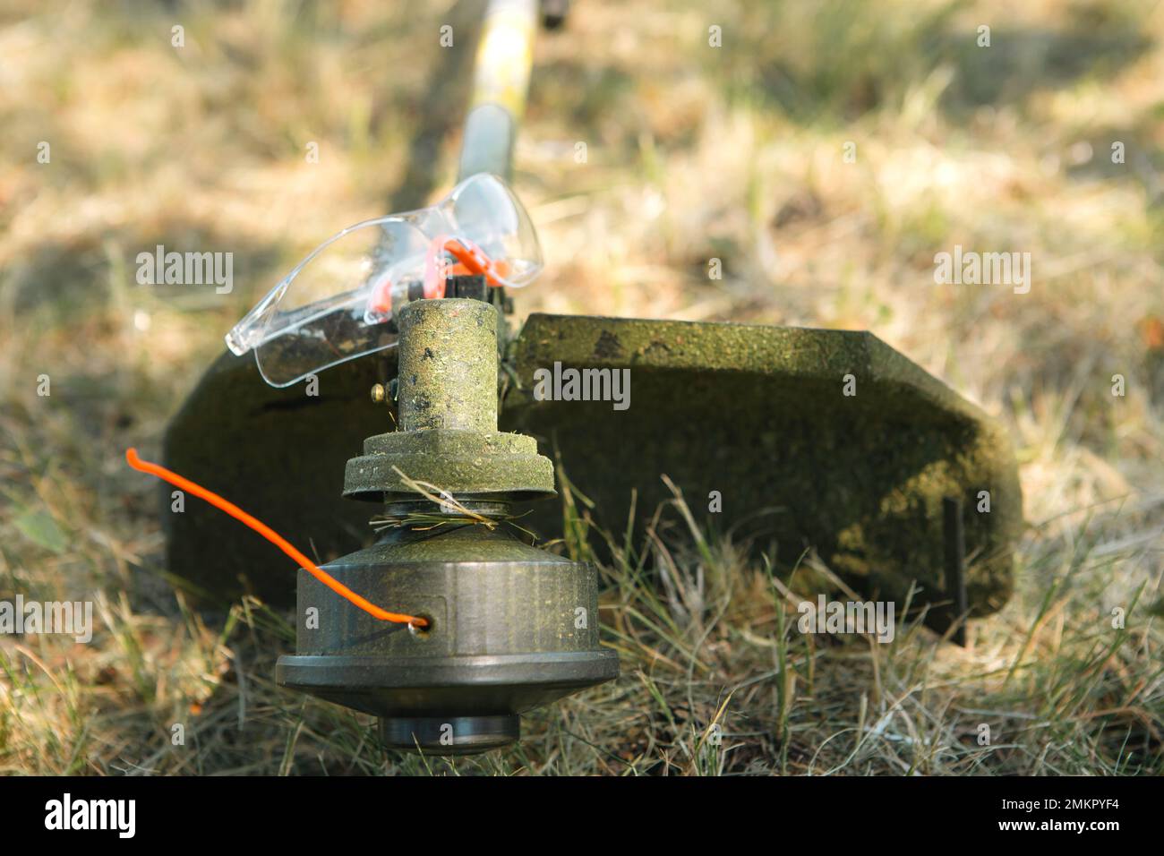 Trimmer after mowing grass closeup. Petrol pump on the grass with