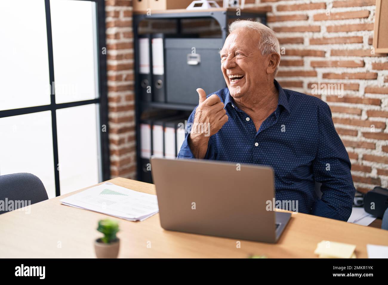 Senior man with grey hair working using computer laptop at the office ...