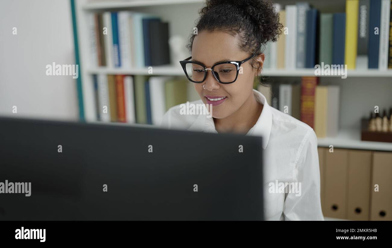 African american woman student using computer studying at library ...