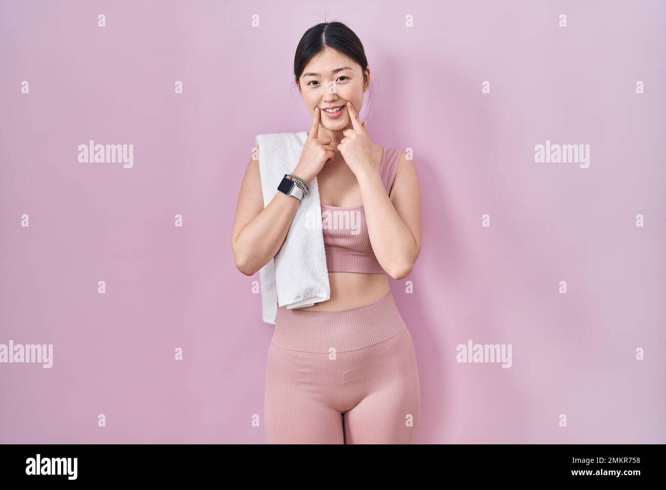 Chinese young woman wearing sportswear and towel smiling with open ...