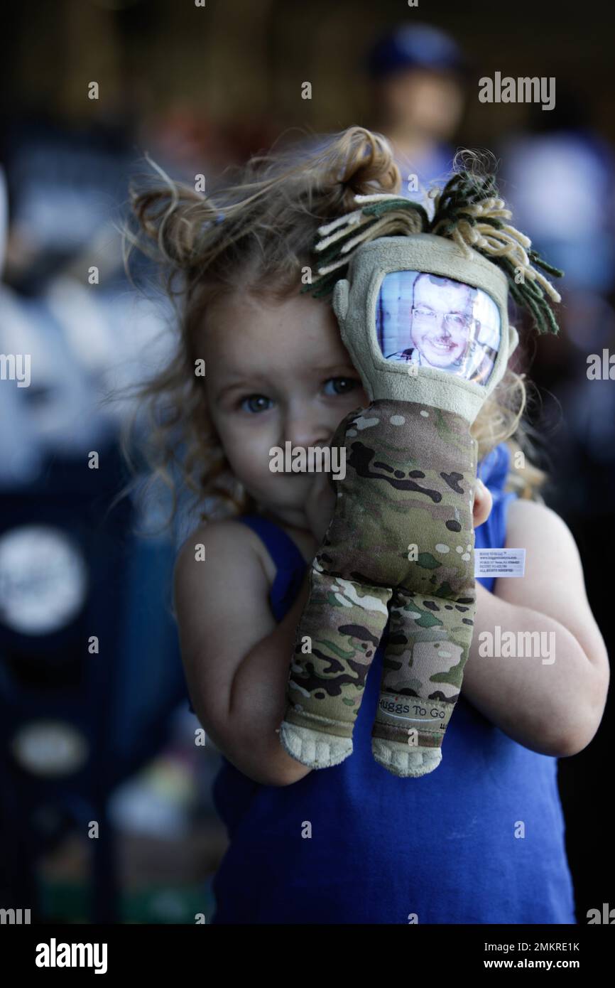 The daughter of a deployed 35th Infantry Division Soldier, holds a doll that resembles her father at Kauffman Stadium, Kansas City, Mo., Sept. 11, 2022. Families and friends of the 35th Infantry Division came out to Kauffman Stadium to spend the day watching baseball and showing their support for their deployed Soldiers.(U.S. Army National Guard photos by Spc. Rose Di Trolio) Stock Photo