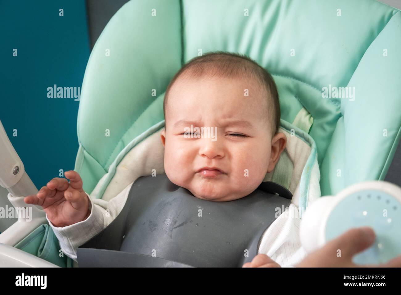 The baby is naughty at the table on the high chair. Hungry upset child