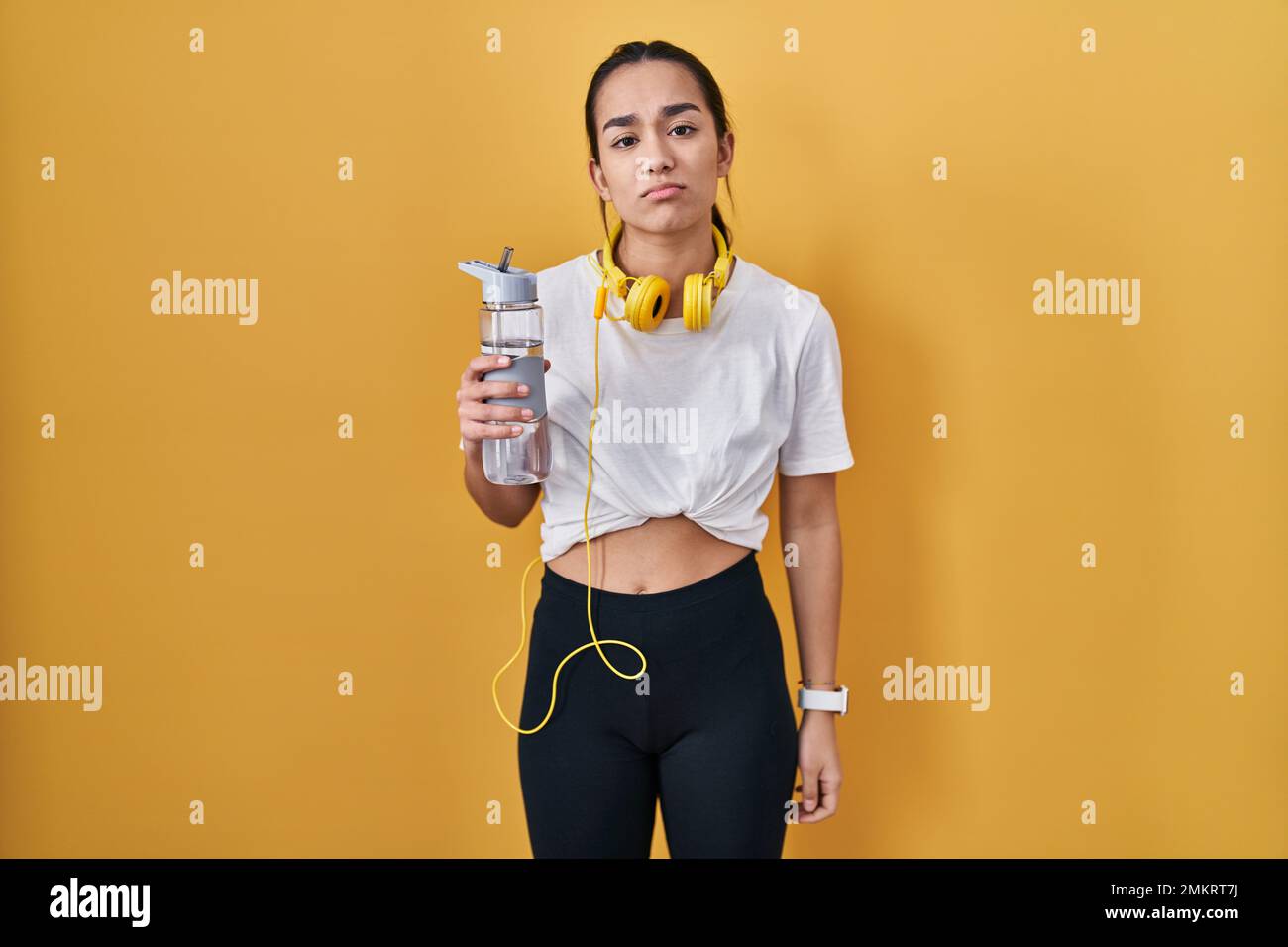 https://c8.alamy.com/comp/2MKRT7J/young-south-asian-woman-wearing-sportswear-drinking-water-looking-sleepy-and-tired-exhausted-for-fatigue-and-hangover-lazy-eyes-in-the-morning-2MKRT7J.jpg