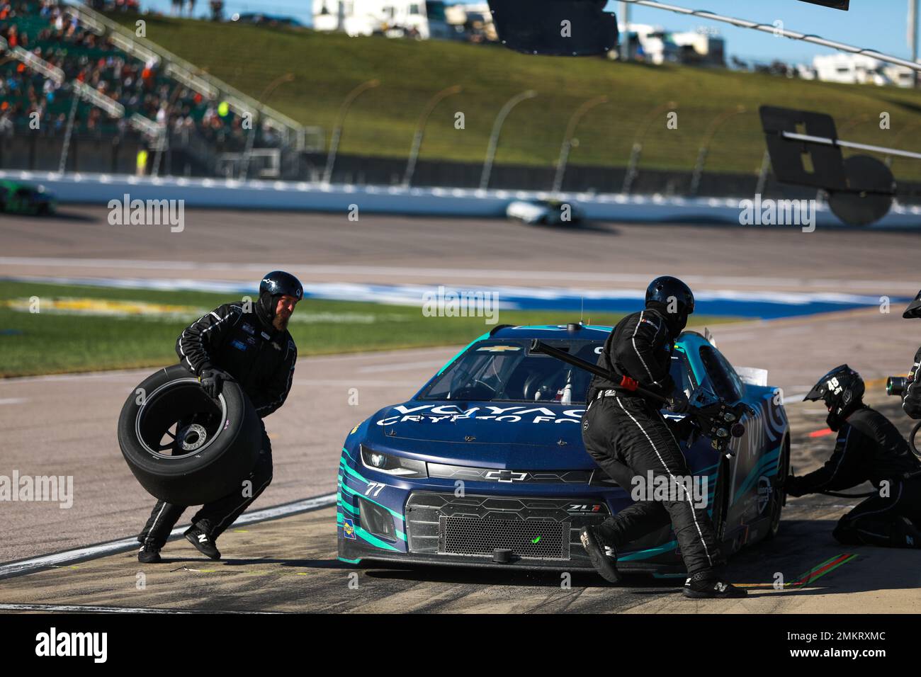 A pit crew changes the tires and windshield cover and fuels up a