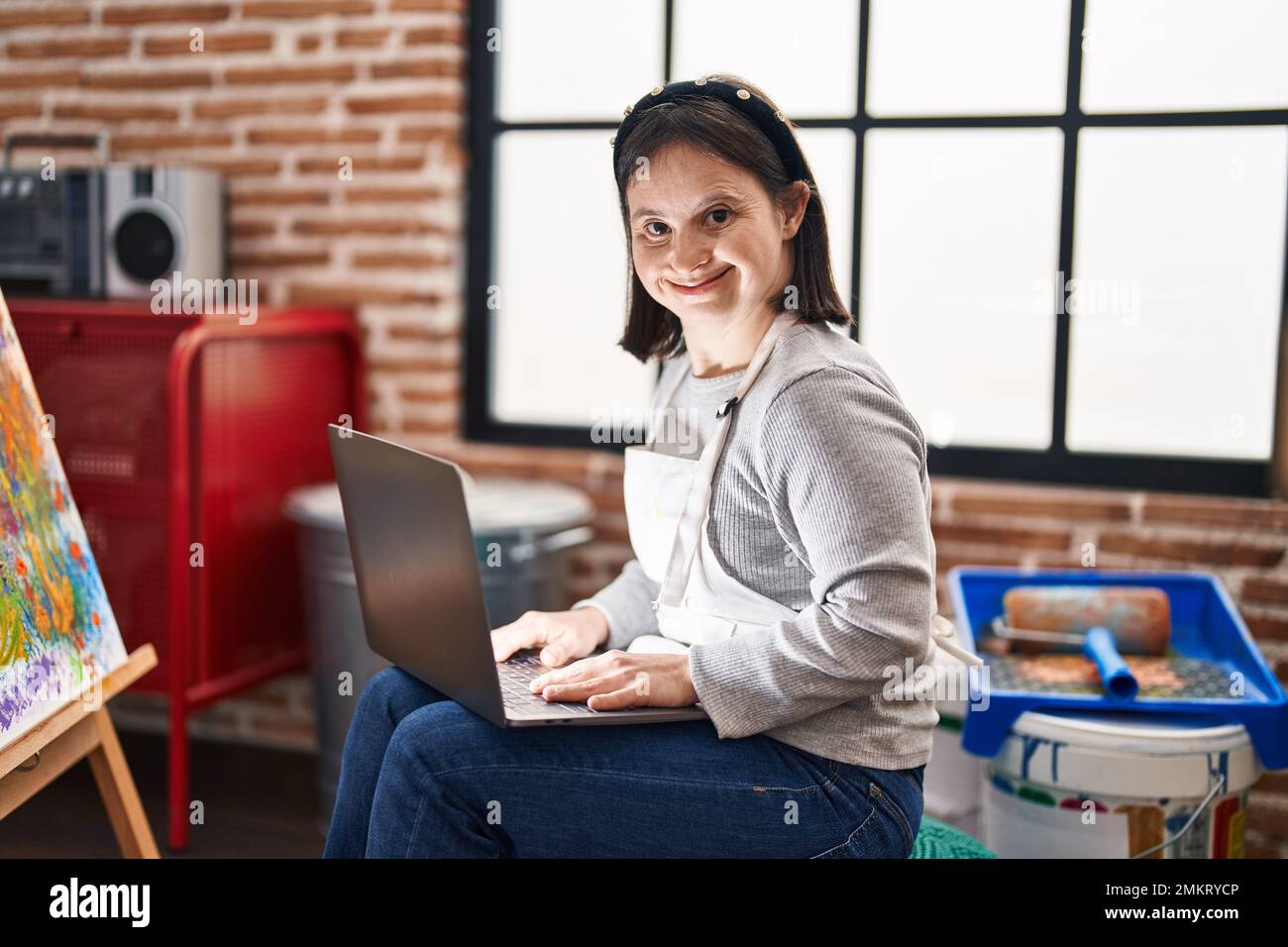 Young Woman With Down Syndrome Artist Using Laptop Drawing At Art 