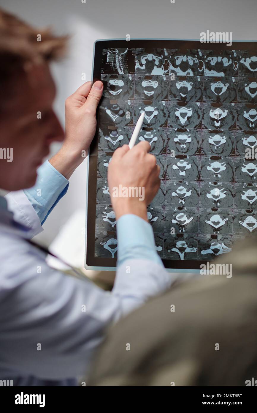 Radiologist showing x-ray image of spine discs to soldier and explaining recovery process Stock Photo