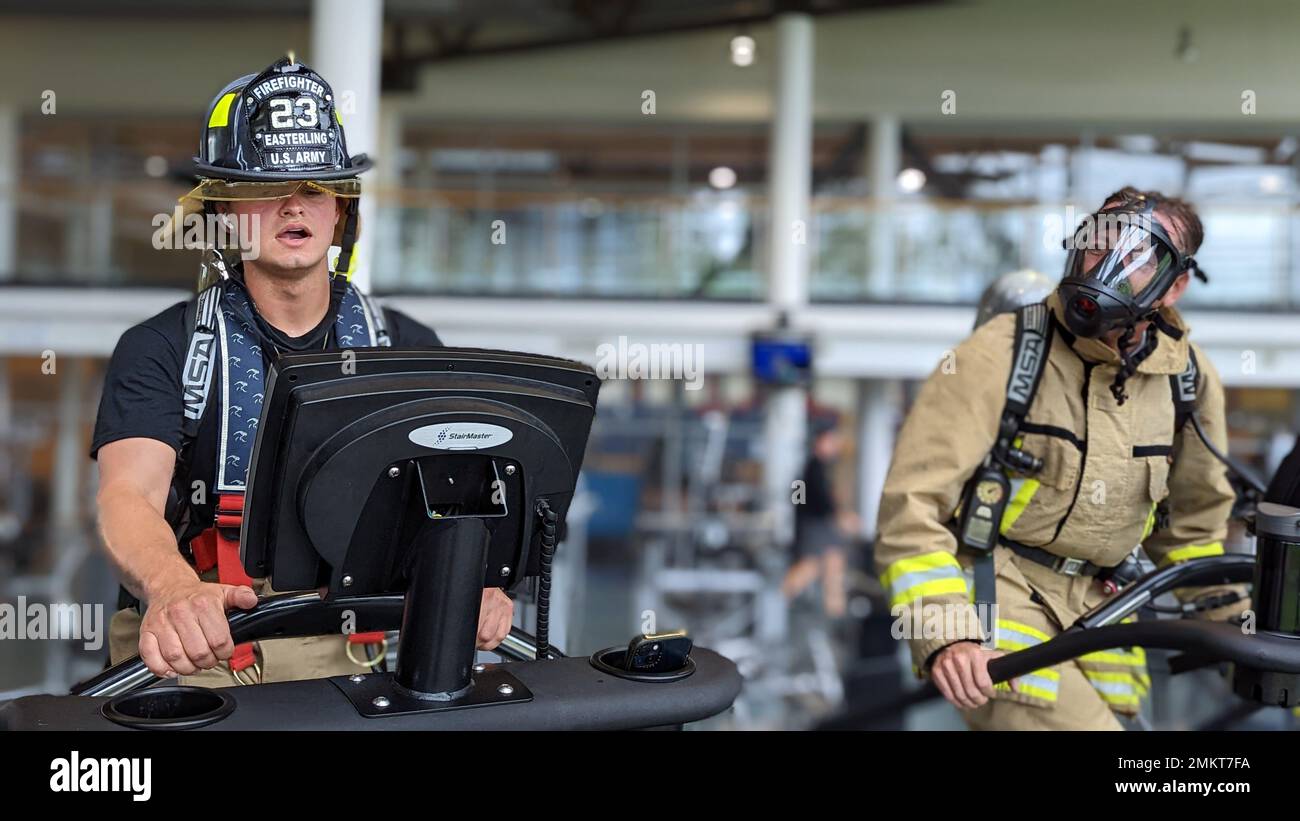 U.S. Army Pfc. Mason Easterling, a firefighter, and 1st Sgt. Thomas Waelty, an ammunition specialist, both assigned to 23rd Ordnance Company, 18th Combat Sustainment Support Battalion, 16th Sustainment Brigade use stair climber machines while wearing firefighting equipment at the Tower Barracks Physical Fitness Center in Grafenwoehr, Germany, Sep. 11, 2022. The Soldiers each climbed 110 stories in memory of sacrifices made by firefighters responding to the September 11 terror attacks at the World Trade Center in New York City 21 years prior. Stock Photo