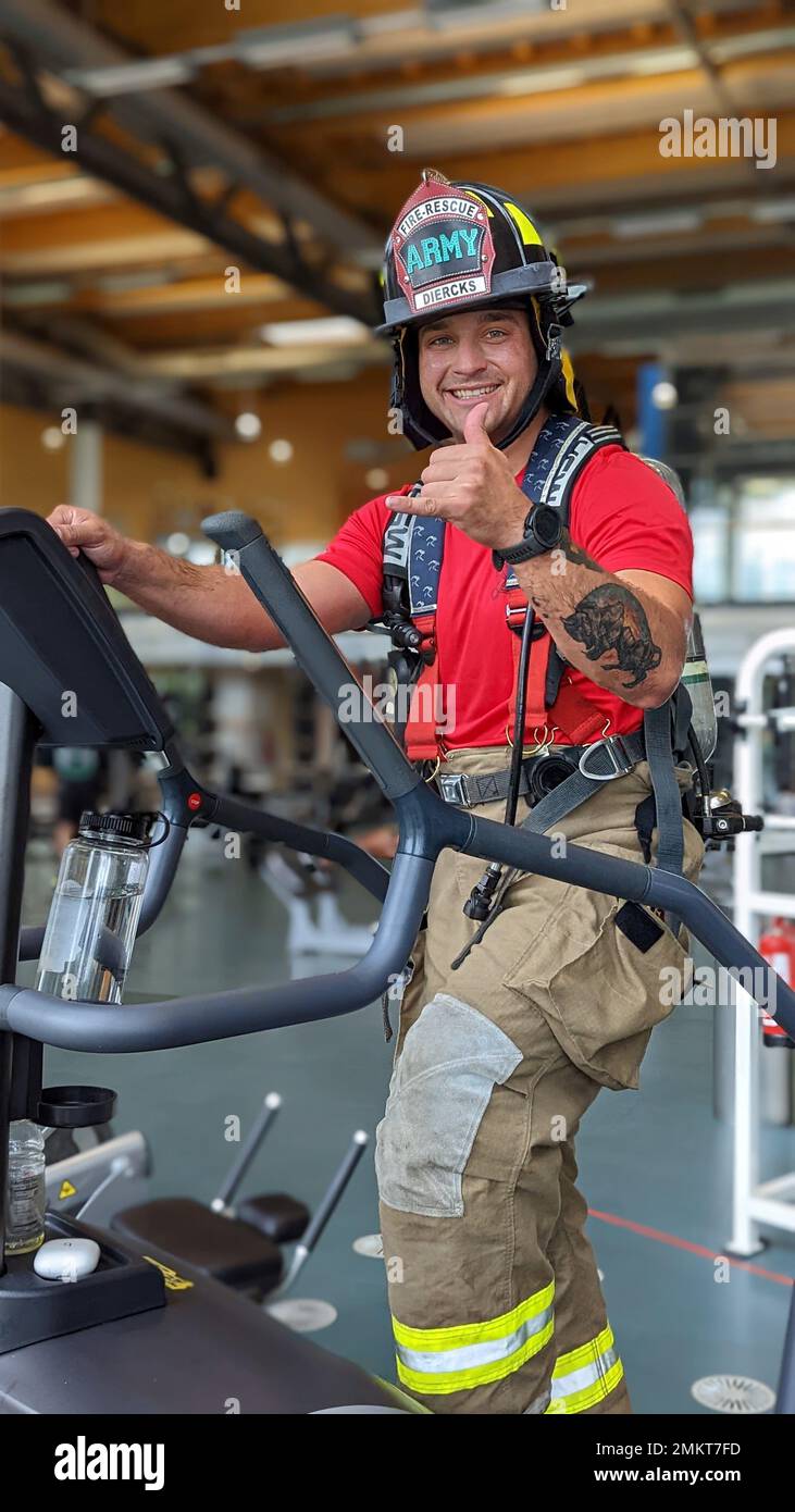 U.S. Army Spc. Nicholas Diercks, a firefighter assigned to 23rd Ordnance Company, 18th Combat Sustainment Support Battalion, 16th Sustainment Brigade uses a stair climber machine while wearing firefighting equipment at the Tower Barracks Physical Fitness Center in Grafenwoehr, Germany, Sep. 11, 2022. Diercks and Soldiers from his company – an Army firefighting unit – each climbed 110 stories in memory of sacrifices made by firefighters responding to the September 11 terror attacks at the World Trade Center in New York City 21 years prior. Stock Photo