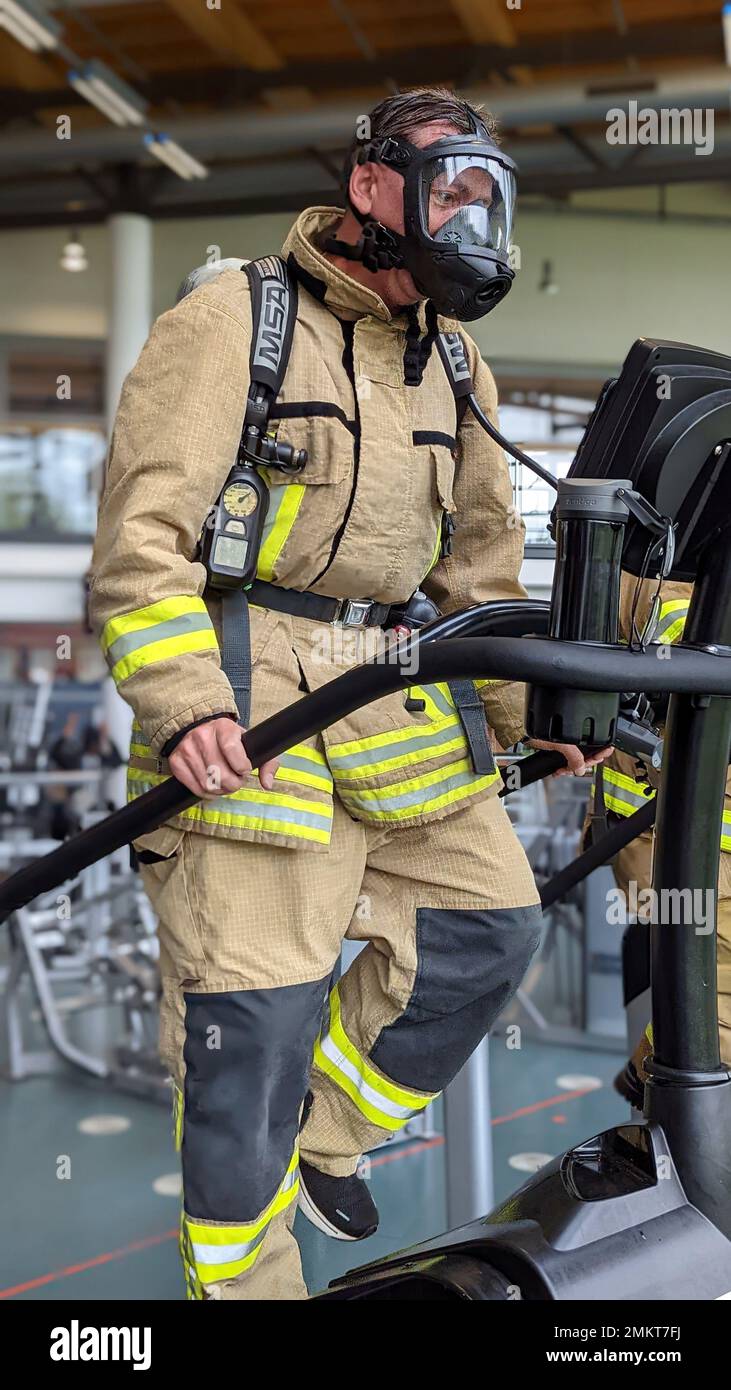 U.S. Army 1st Sgt. Thomas Waelty, an ammunition specialist assigned to 23rd Ordnance Company, 18th Combat Sustainment Support Battalion, 16th Sustainment Brigade, uses a stair climber machine while wearing firefighting equipment at the Tower Barracks Physical Fitness Center in Grafenwoehr, Germany, Sep. 11, 2022. Waelty and Soldiers from his company – an Army firefighting unit – each climbed 110 stories in memory of sacrifices made by firefighters responding to the September 11 terror attacks at the World Trade Center in New York City 21 years prior. Stock Photo