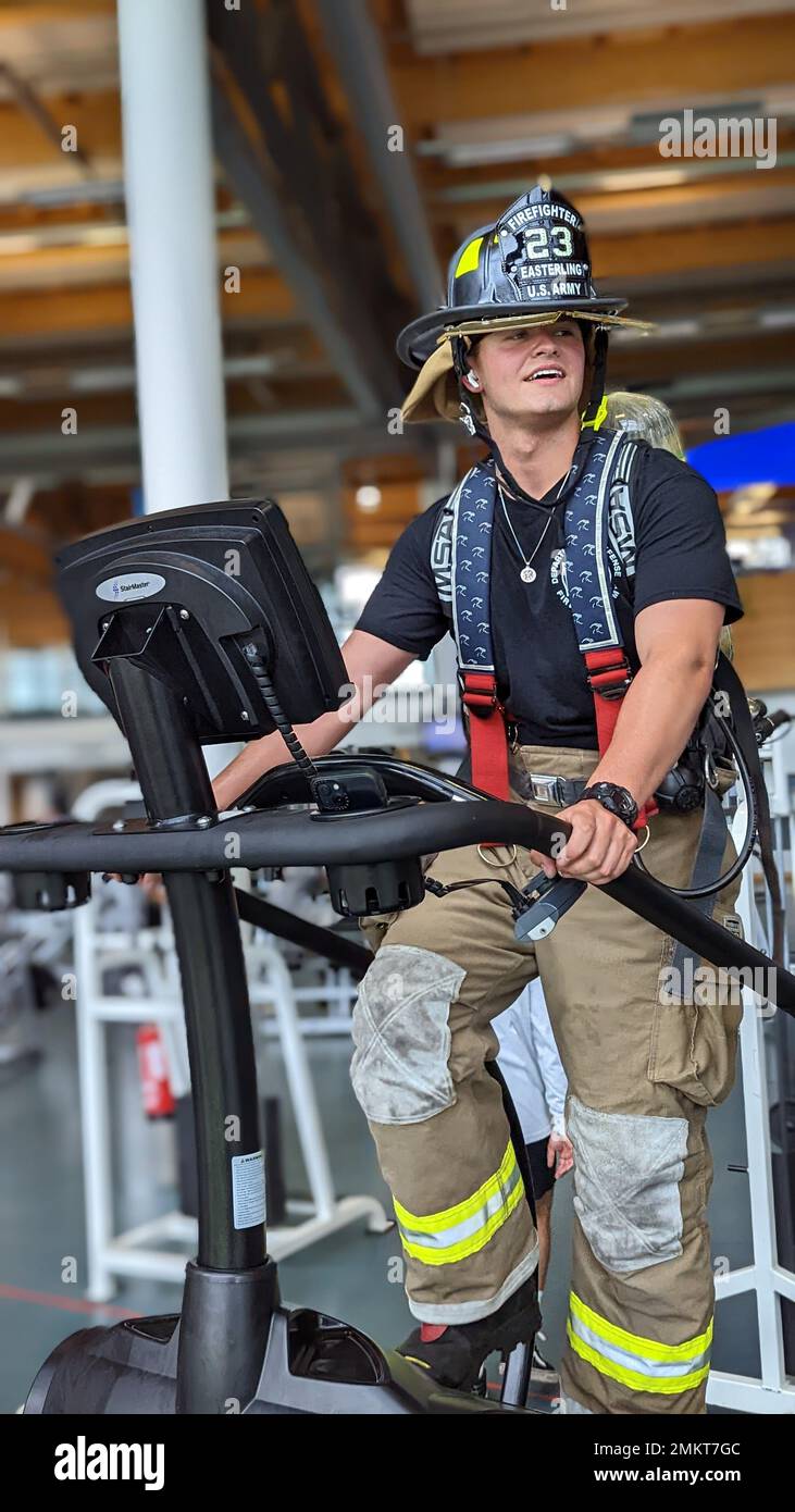 U.S. Army Pfc. Mason Easterling, a firefighter assigned to 23rd Ordnance Company, 18th Combat Sustainment Support Battalion, 16th Sustainment Brigade uses a stair climber machine while wearing firefighting equipment at the Tower Barracks Physical Fitness Center in Grafenwoehr, Germany, Sep. 11, 2022. The Soldiers each climbed 110 stories in memory of sacrifices made by firefighters responding to the September 11 terror attacks at the World Trade Center in New York City 21 years prior. Stock Photo