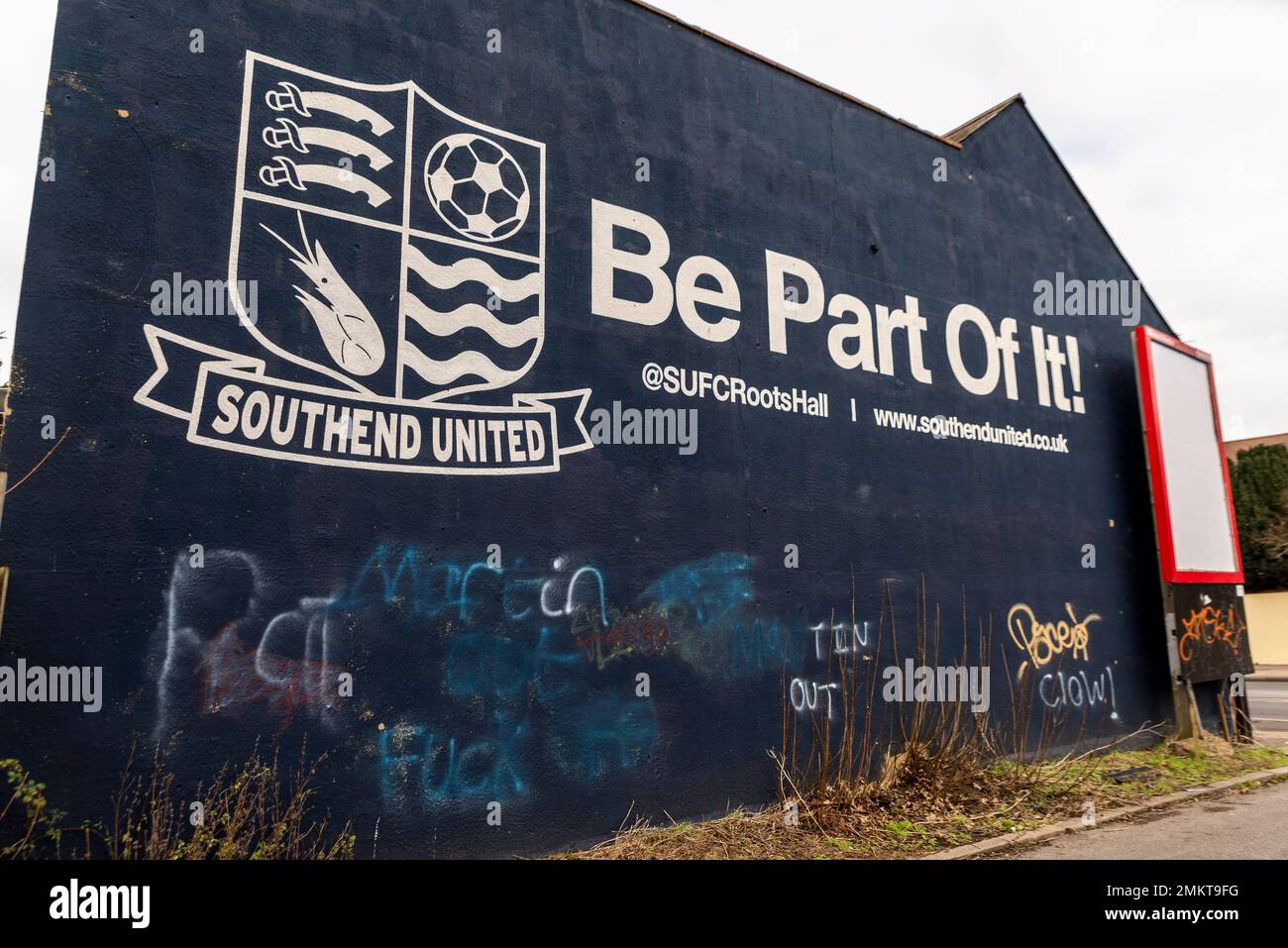 Badge, slogan at Roots Hall stadium of Southend Utd football ground, Southend on Sea, Essex, UK. Be part of it. Anti Ron Martin graffiti painted over Stock Photo