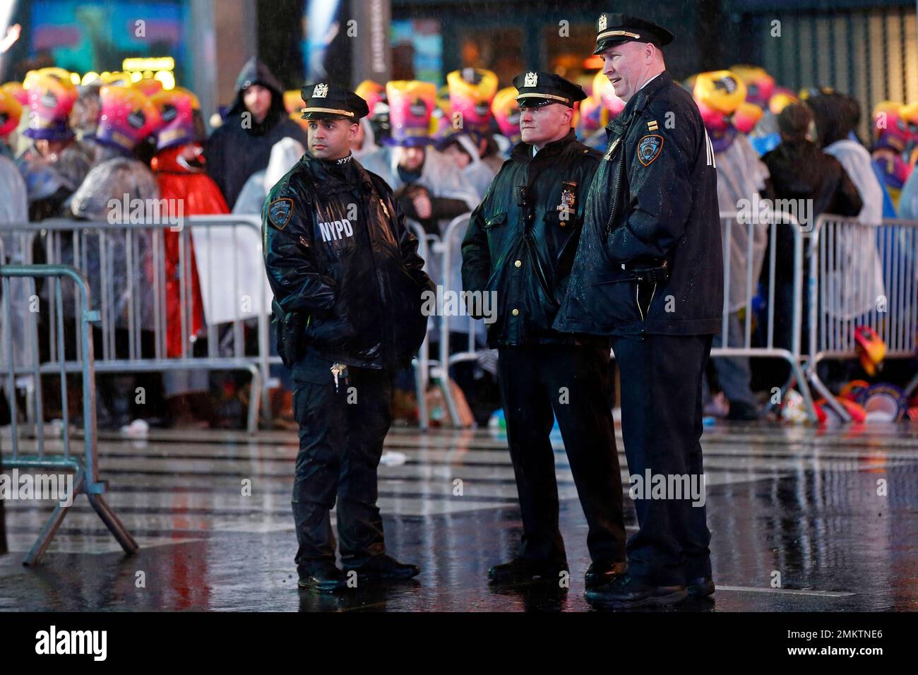 New York City police officers stand near revelers in Times Square in ...