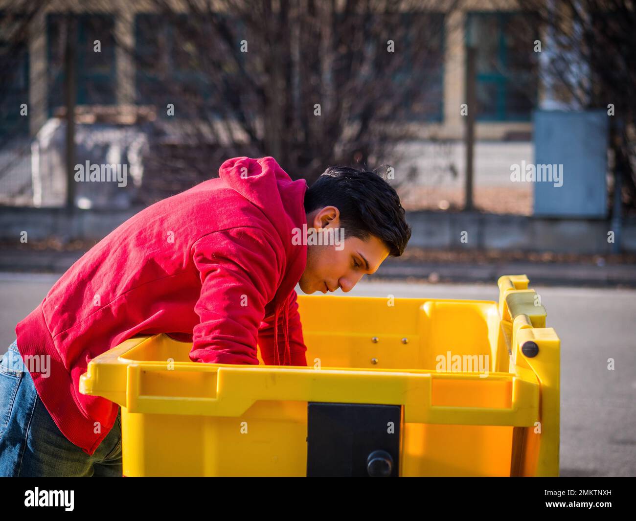 Attractive young man putting out rubbish standing Stock Photo