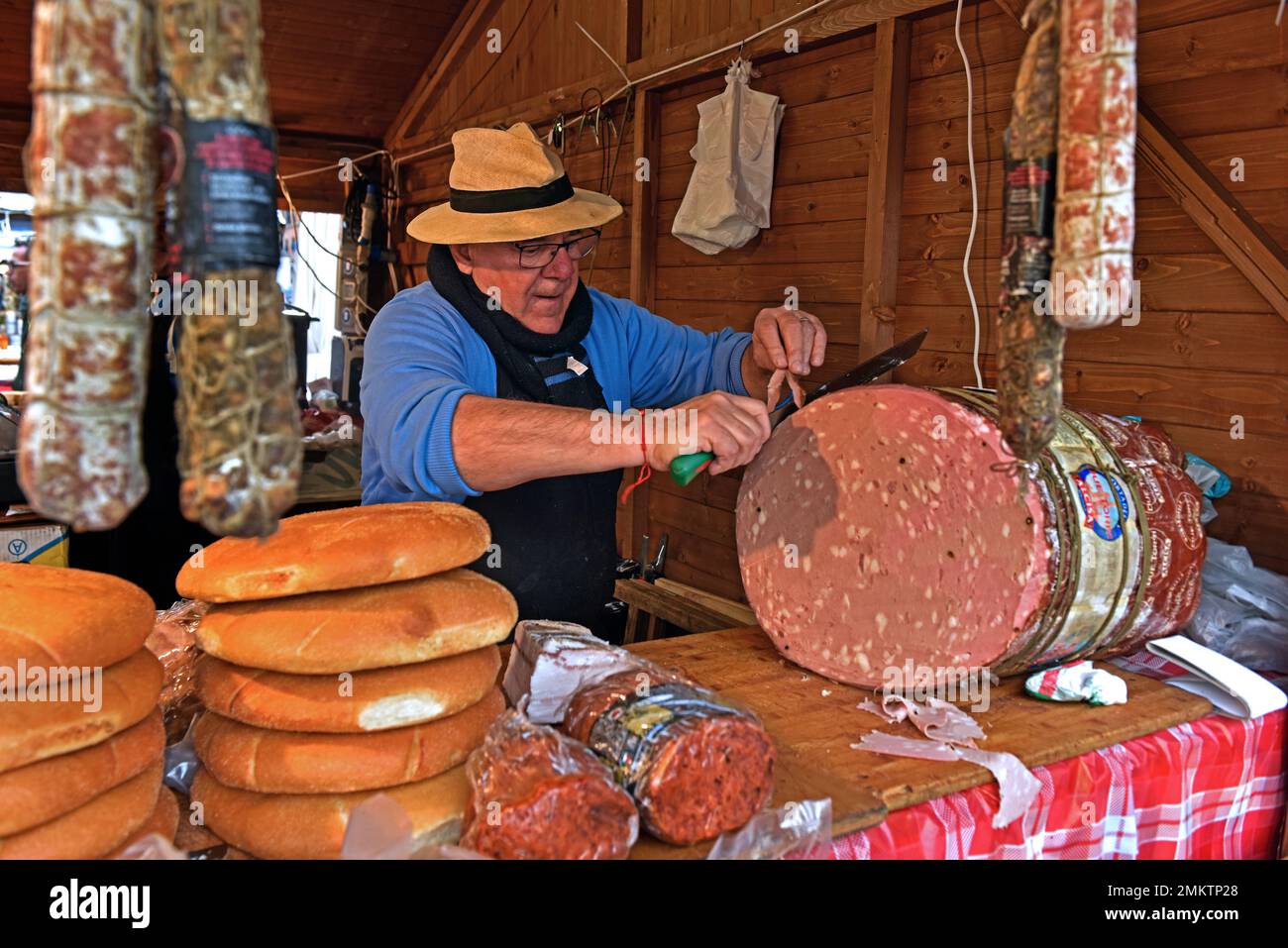 Shopman cuts a mortadella sausage Stock Photo