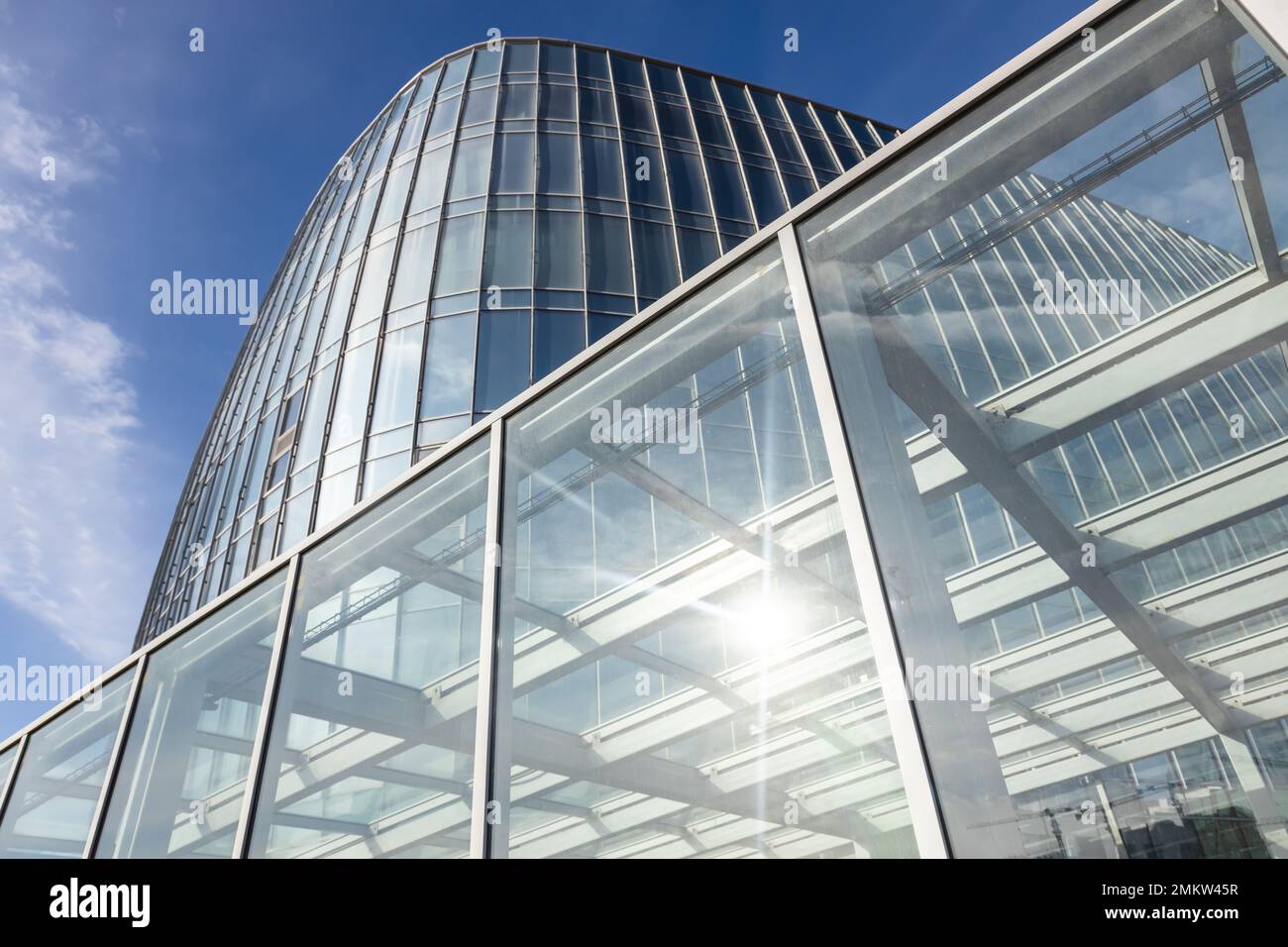 The blue sky is reflected in the windows of a modern office building ...