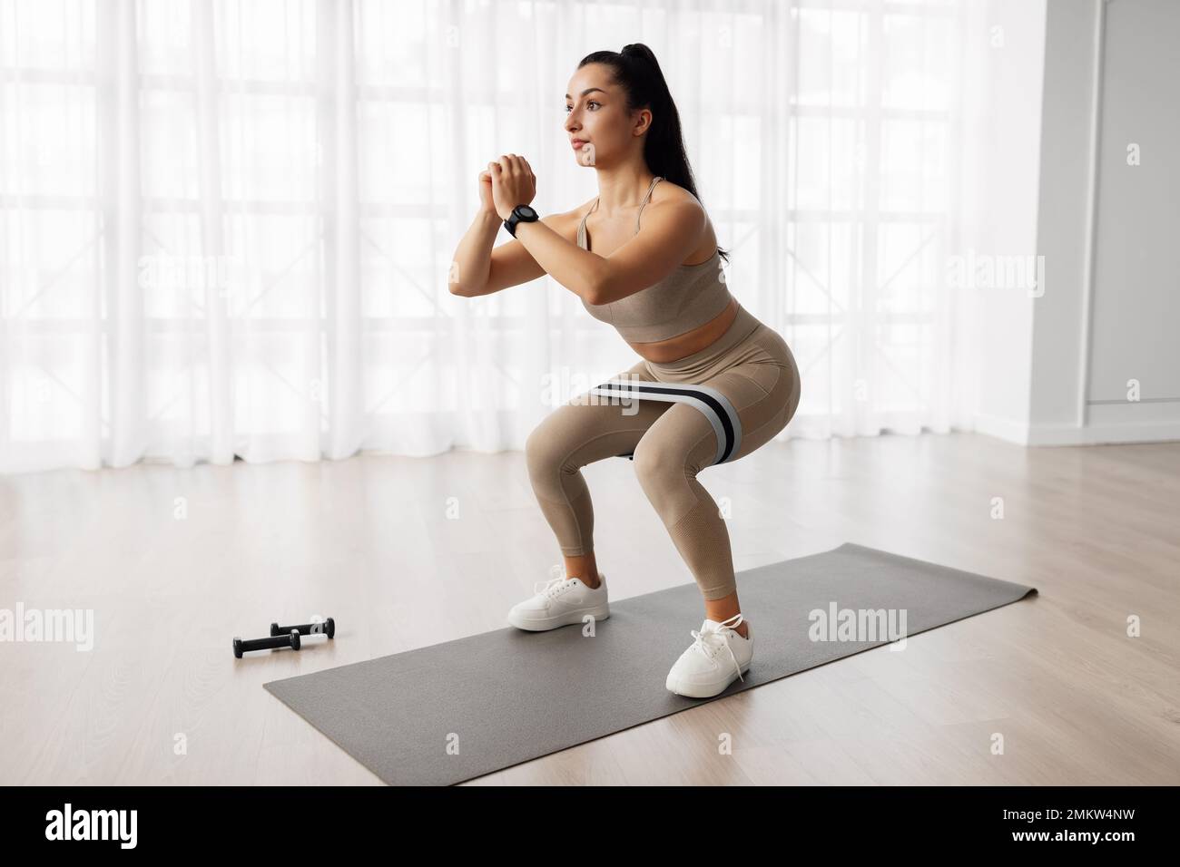 Motivated young woman doing workout at home Stock Photo
