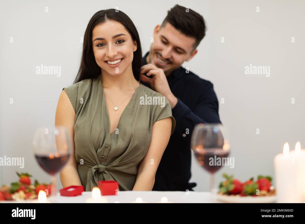 Happy young couple in love drinking wine, celebrating Valentines day Stock Photo