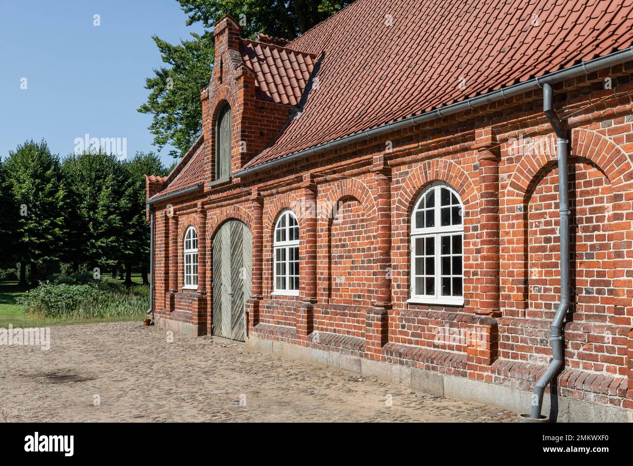 Red brick façade of the old stables in the garden of Rosenholm Castle, Jutland, Denmark Stock Photo