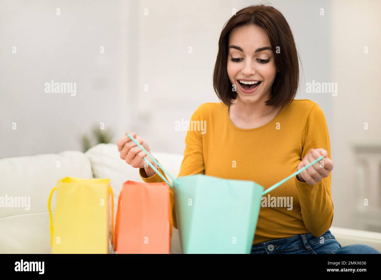 Overjoyed young woman customer receive purchases, home interior Stock Photo