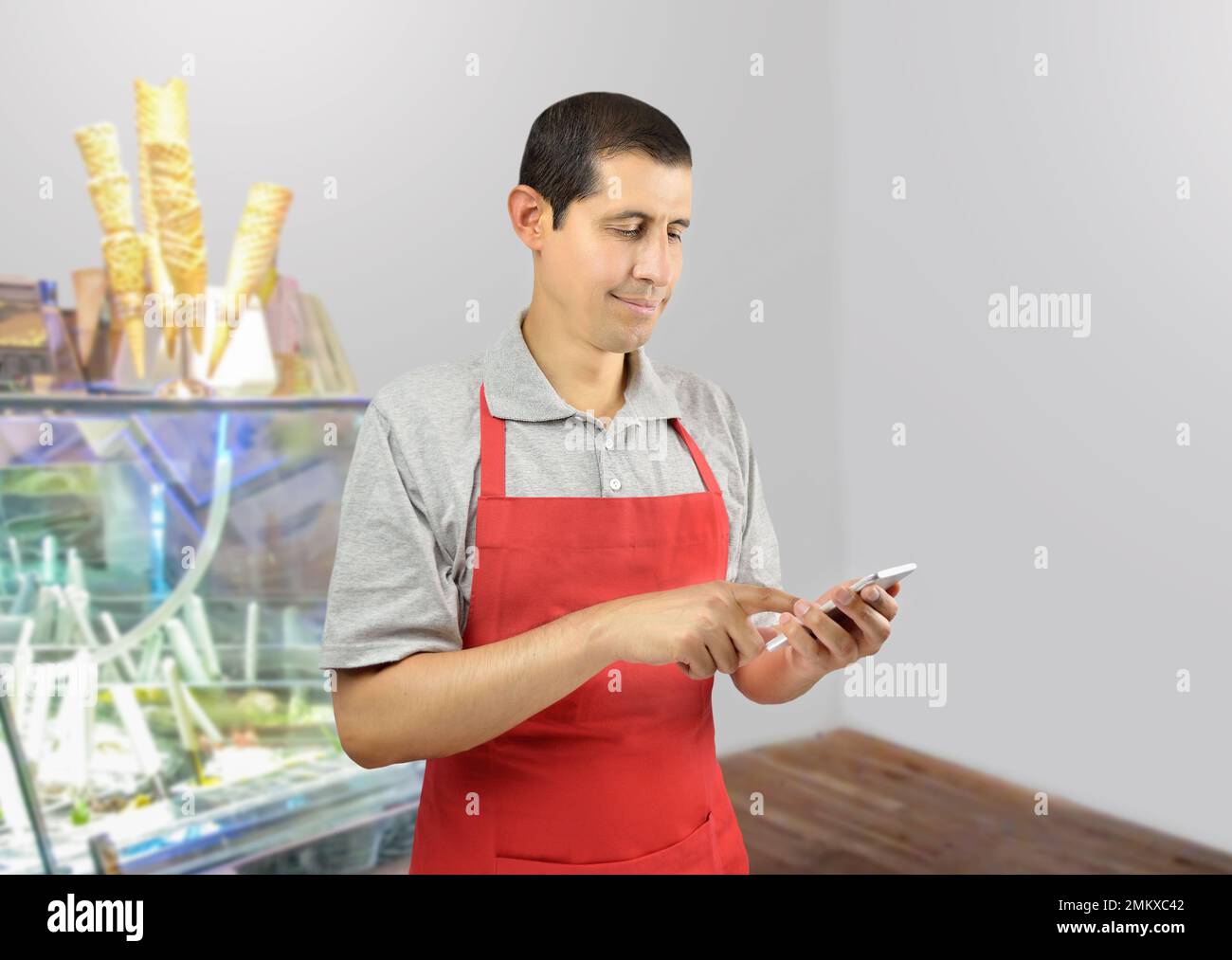 Smiling ice cream store employee standing behind the counter in the