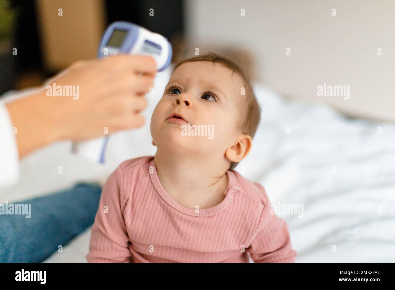 Healthcare for infant child. Mother measuring temperature of her baby