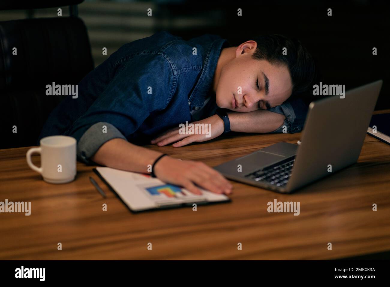Young man manager sleeping at workdesk at office Stock Photo