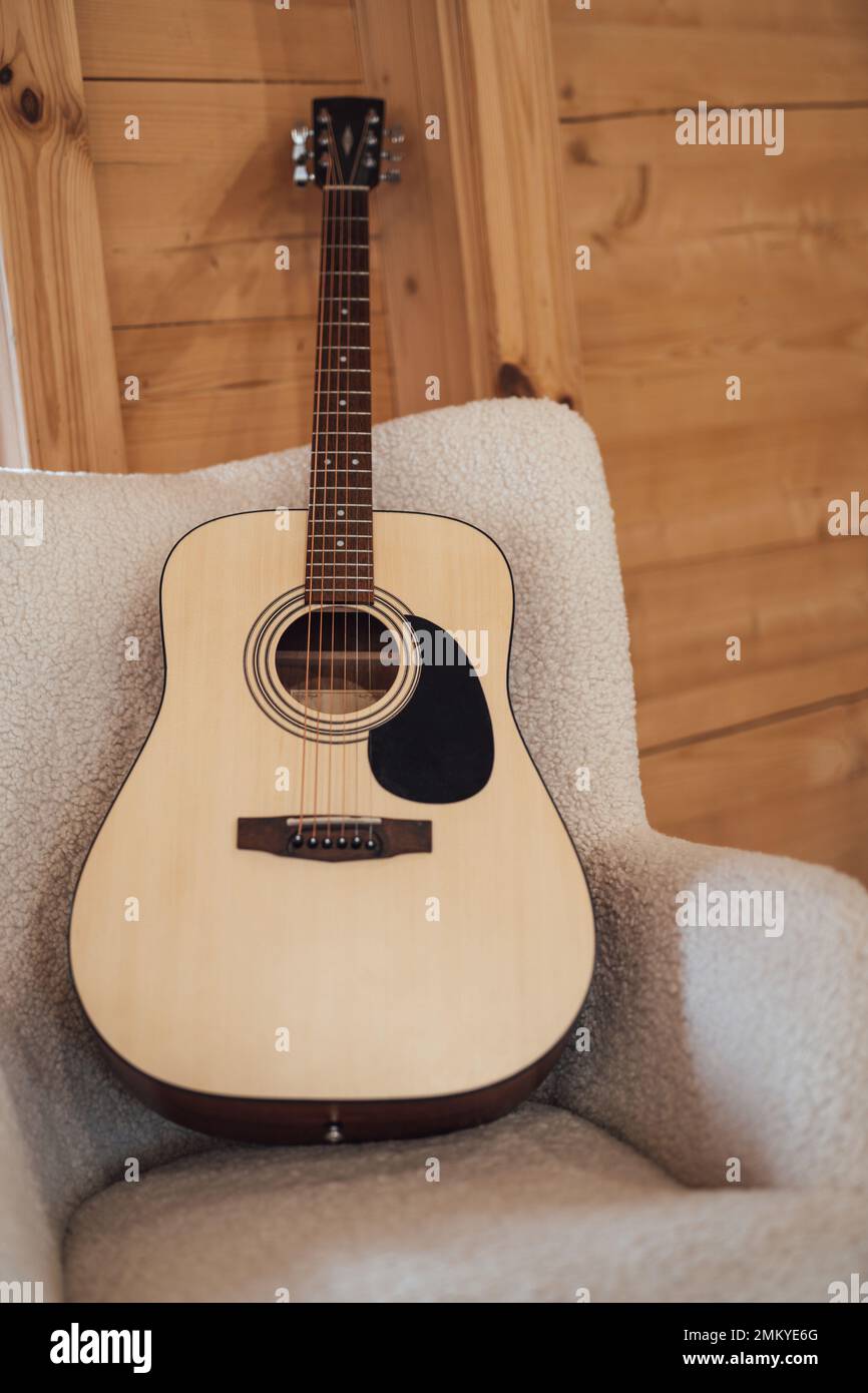 full size classical acoustic guitar on chair in interior Stock Photo