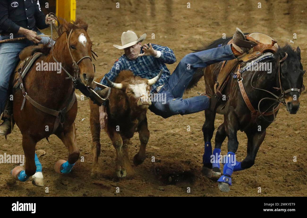Hunter Cure, of Holliday, Texas, competes in the steer wrestling event ...