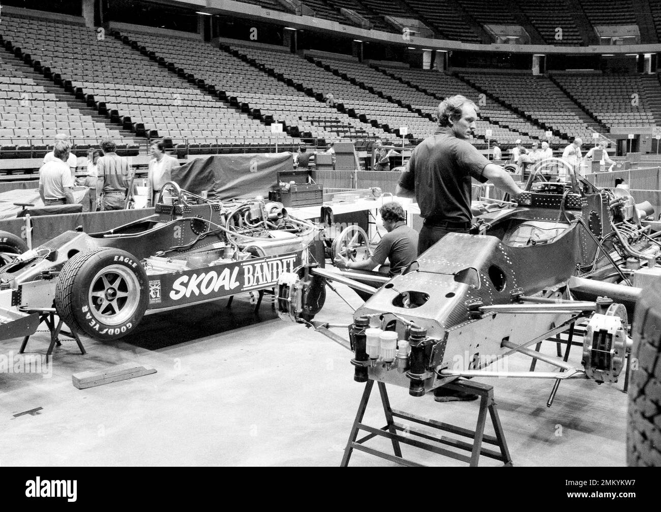 Mechanics put the rear deck on Mario Andretti's Lola race car at the