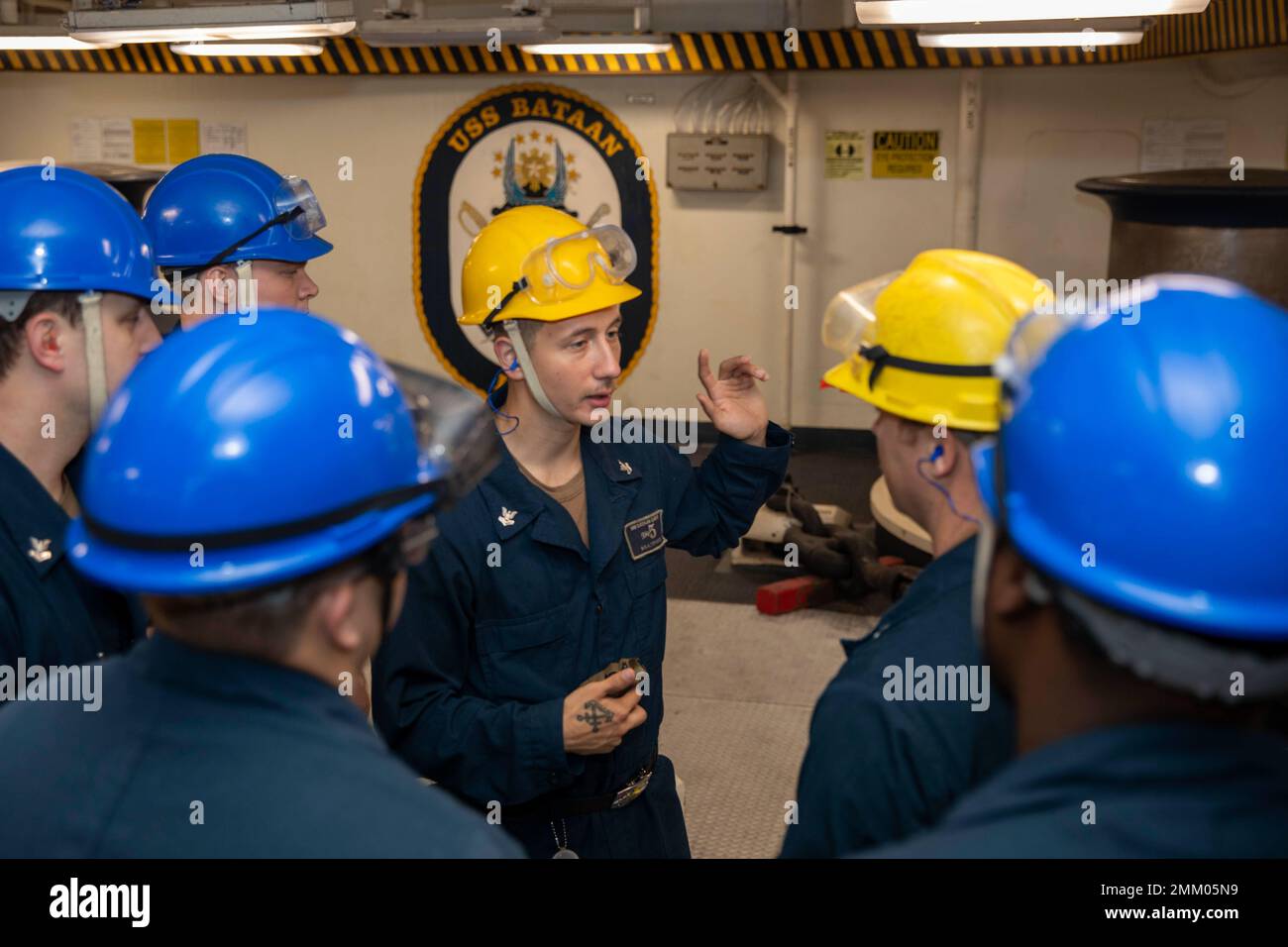 220912-N-VO895-1007  ATLANTIC OCEAN (Sept. 12, 2022) Boatswain’s Mate 2nd Class David Boatright, assigned to the Wasp-class amphibious assault ship USS Bataan (LHD 5) Deck Department, briefs Sailors prior to an anchor drop evolution in the ship’s forecastle, Sept. 12, 2022. Bataan is underway conducting deck landing qualifications as part of the basic phase training cycle. Stock Photo