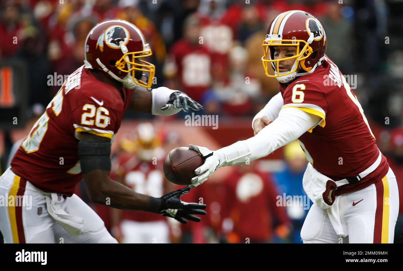 Washington Redskins running back Adrian Peterson (26) takes the hand off from quarterback Mark