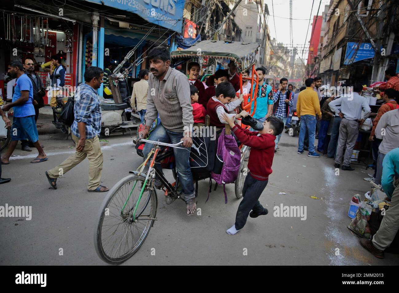 Altaf Rickshwa A school boy chases a rickshaw carrying his school mates through a ...