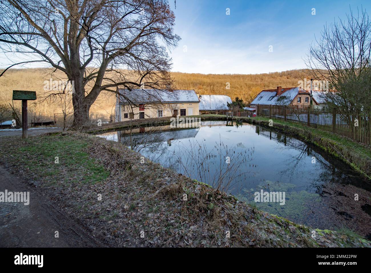 Pond and buildings of a former mill at Koda, Czech Karst. A karst spring was collected here and then used to run a mill hewn in travertine heap. Stock Photo