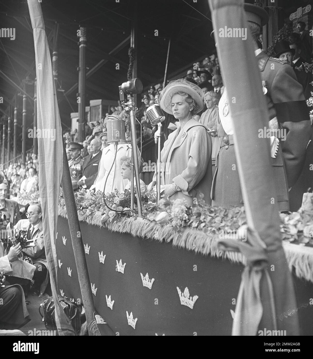 Carl XVI Gustaf, King of Sweden. Born 30 april 1946. Sports event at Stockholm's Stadium 1951 where the participants enter the arena and the audience stands up to get a better view. Prince Carl Gustaf with his mother Sibylla and hidden behind a pillar King Gustaf the VI Adolf. Kristoffersson ref BC52-9 Stock Photo