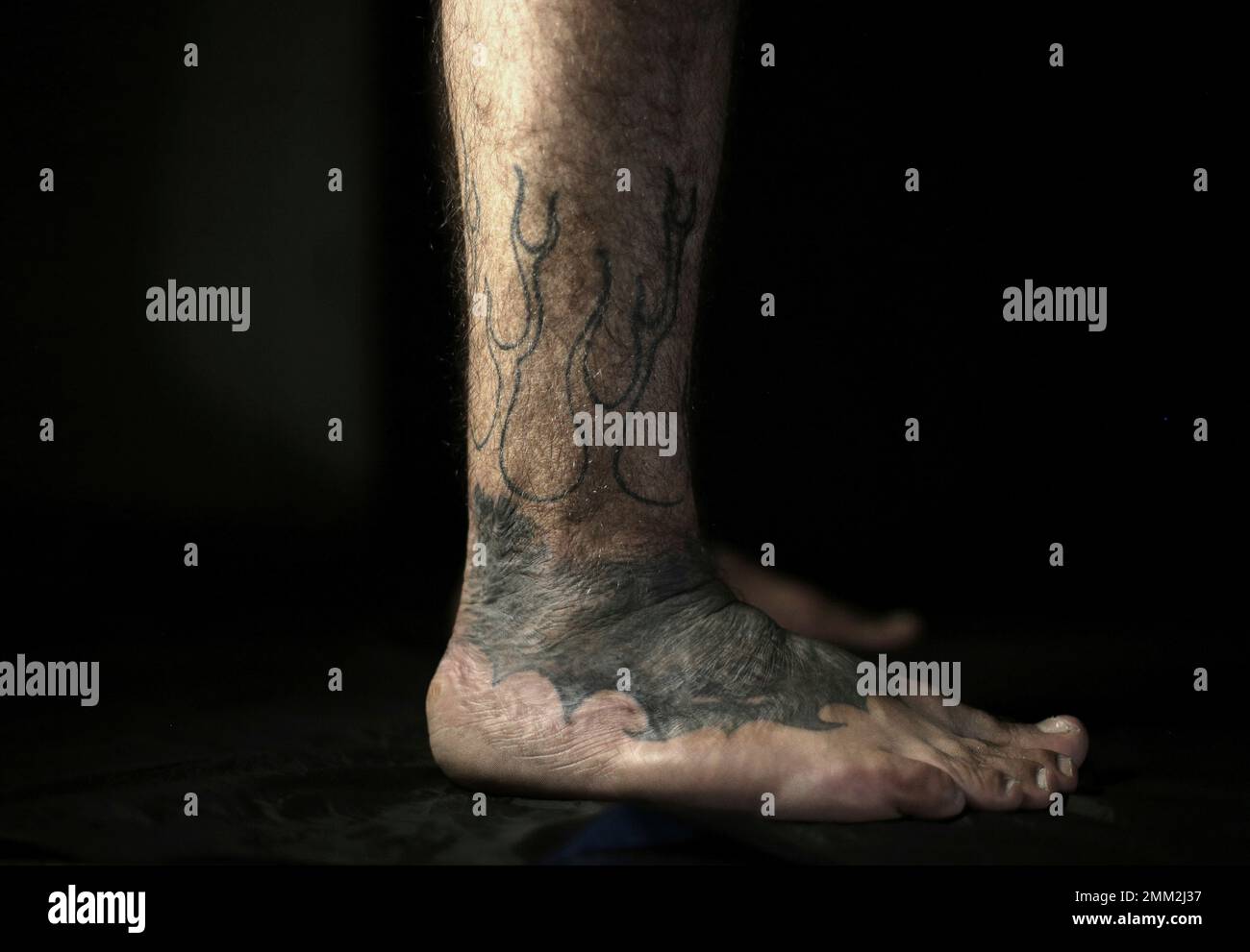 In this Wednesday, Oct. 24, 2018, photo, Iraqi soldier Saad Khudeir  displays his tattoo on his leg covering scars of the burns he suffered in a  car bomb attack, in Baghdad, Iraq., image size:1300x991