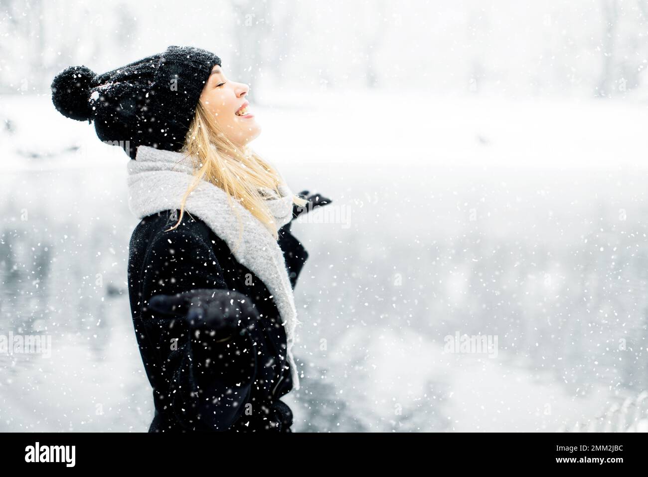 Pretty young woman n warm clothes enjoying in snow Stock Photo