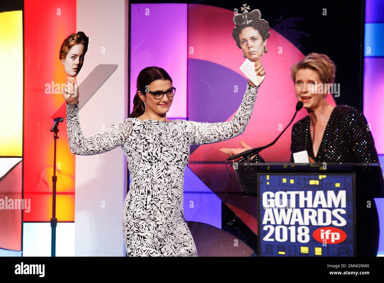 Actress Rachel Weisz, left, holds photos of her costars Emma Stone and