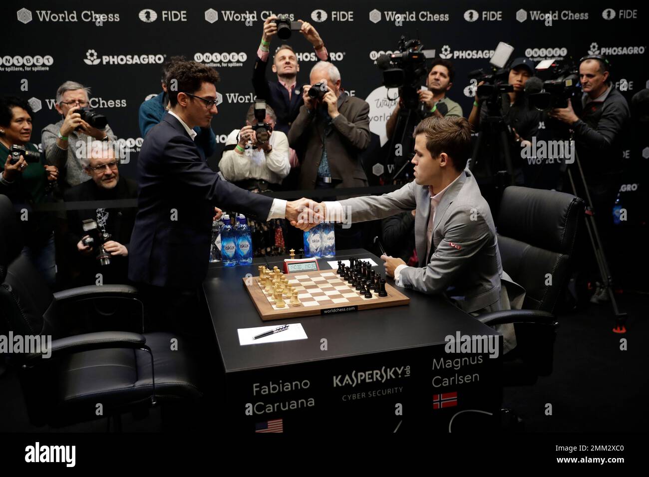 Reigning chess world champion Magnus Carlsen, right, from Norway, plays  Italian-American challenger Fabiano Caruana in the first five minutes of  round three of their World Chess Championship Match in London, Monday, Nov.