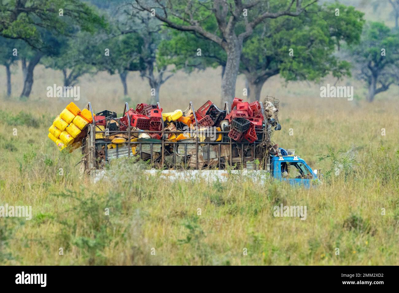 A truck carrying plastic waste for recycling, driving south from South Sudan through Kidepo National Park in Northern Uganda. Stock Photo