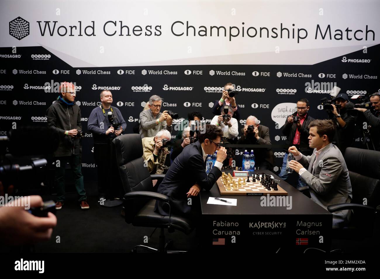 Reigning chess world champion Magnus Carlsen, right, from Norway, plays  Italian-American challenger Fabiano Caruana in the first five minutes of  round three of their World Chess Championship Match in London, Monday, Nov.