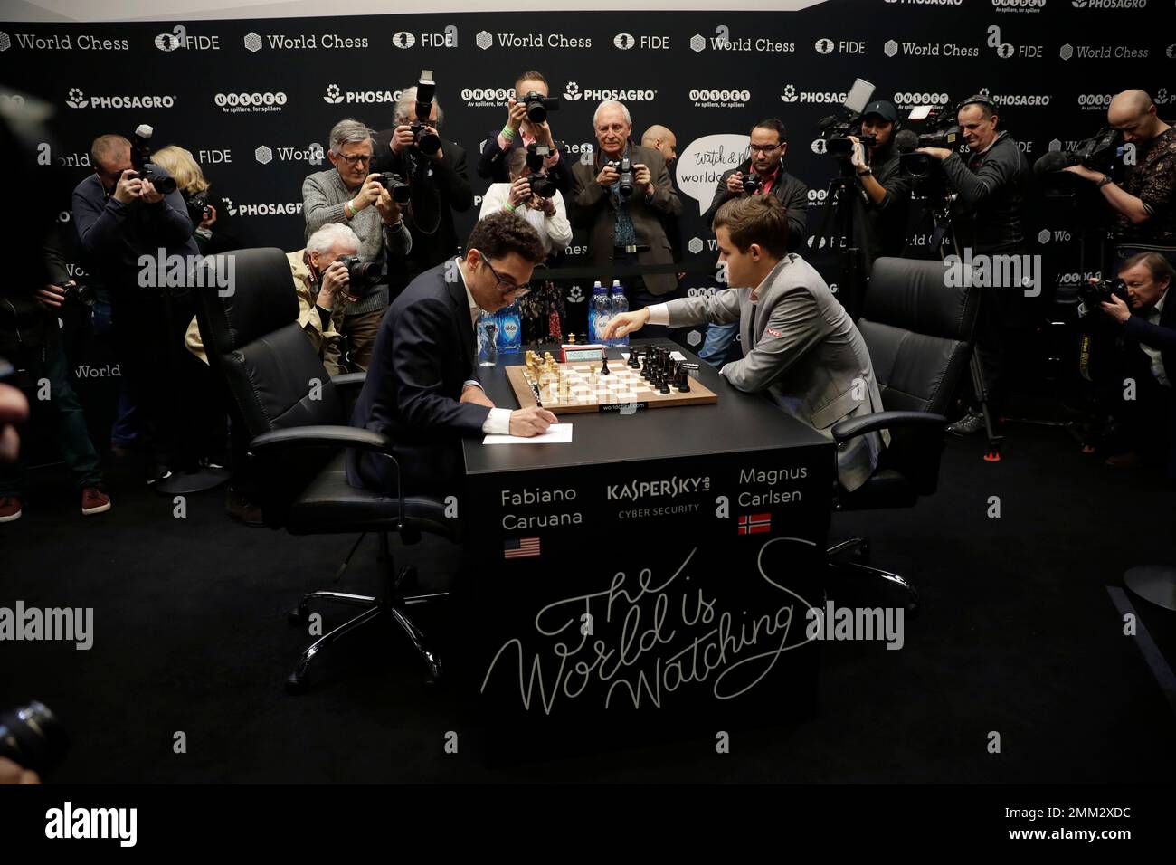 Reigning chess world champion Magnus Carlsen, right, from Norway, plays  Italian-American challenger Fabiano Caruana in the first five minutes of  round three of their World Chess Championship Match in London, Monday, Nov.